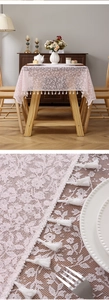 Detail of pink floral lace tablecloth with white fringe tassel and hollow texture