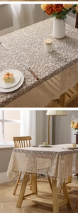 Close-up of beige lace tablecloth with floral hollow patterns and delicate tassel edges