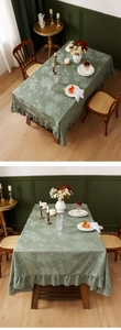 Dettaglio della tovaglia vintage grigio-verde con motivi floreali e bordo con volant