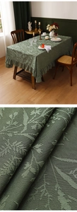 Macro shot of dark green floral jacquard fabric and elegant ruffled lace table runner edge