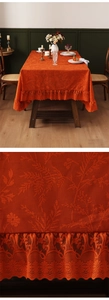 Close-up of vintage orange lace tablecloth showing intricate floral jacquard texture
