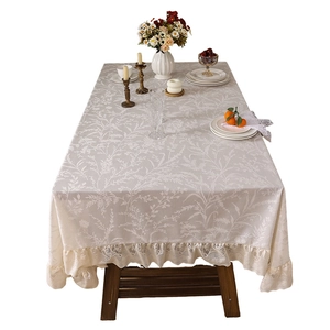 Elegante tovaglia rettangolare in pizzo con motivi vegetali e bordi con volant