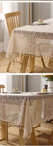 Detailed close-up of floral lace tablecloth fabric with elegant fringe edge decor