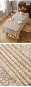 Detailed embroidery and tassel fringe on beige lace tablecloth with floral jacquard texture