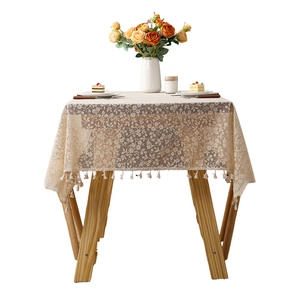 Beige floral lace tablecloth with fringe edge on a table for French retro home decor