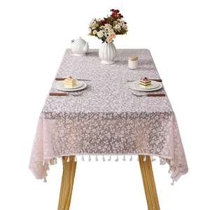 Pink floral lace tablecloth with cotton tassels displayed on a wooden table setup