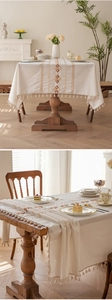 Close-up of bohemian cream cotton tablecloth with geometric embroidery and fringe tassels