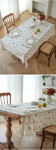 Close-up of fresh floral pattern tablecloth with elegant cotton ball fringe edge detail