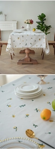 Close-up of dandelion embroidery and tassel fringe on cream cotton linen tablecloth