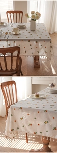 Detailed embroidery of colorful flowers and beige tassels on textured linen tablecloth