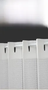 Gros plan du rideau de porte pliant blanc montrant la texture tissée et les œillets