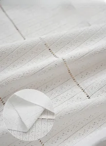 Gros plan du tissu de rideau japonais blanc montrant la texture mesh et les motifs ajourés