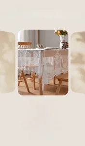 Close-up of French vintage lace tablecloth featuring floral embroidery and fringe tassels