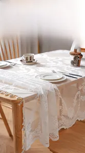 Close-up of French lace tablecloth featuring floral hollow patterns and delicate tassels