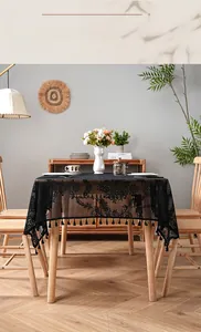 Detail of black lace tablecloth with floral hollow patterns and delicate tassel edges