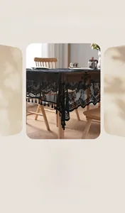 Close-up of black lace tablecloth featuring intricate floral embroidery and fringe edge