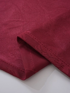 Close-up of burgundy lace curtain fabric showing detailed stitching and mesh texture