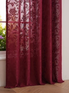 Detailed view of burgundy lace sheer curtain with floral jacquard on wooden floor