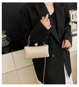 Dettaglio della pochette glitterata con elegante chiusura a perla e catena oro