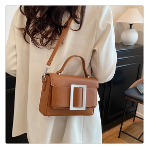 Detailed macro view of caramel lychee texture leather handbag with silver square buckle