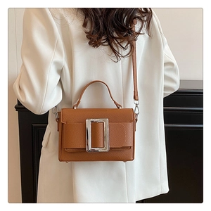 Brown litchi grain leather bag detail with silver square buckle shown on model