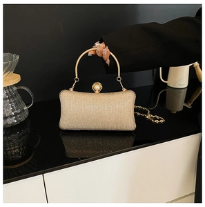 Dettaglio pochette glitter color champagne con chiusura a perla e manico tondo in metallo