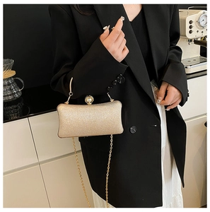 Dettaglio della pochette di paillettes oro champagne con chiusura di perle e catena