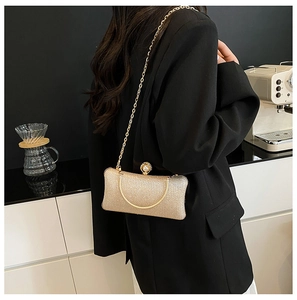 Dettaglio di un'elegante pochette dorata con paillettes e chiusura a perla