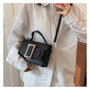 Detail of black lychee grain leather handbag with iconic silver square metal buckle