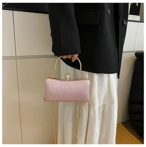 Dettaglio della borsa da sera rosa glitterata con chiusura a perla e manico oro