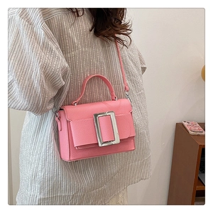 Detail of pink lychee leather crossbody bag featuring a silver rectangular buckle