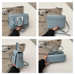 Detail view of sky blue bag showing front buckle, side profile, and protective base studs