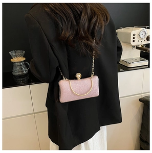 Borsa da sera rosa con paillettes, manico dorato e chiusura a perla sulla spalla