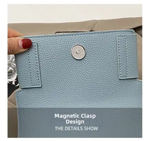 Detail of light blue lychee pattern leather handbag with silver magnetic snap closure