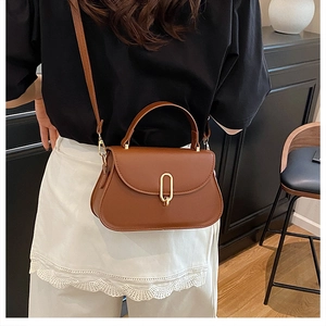 Détail d'un sac à main en cuir caramel avec fermoir doré vintage et poignée supérieure