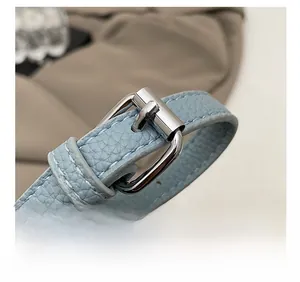 Macro shot of light blue lychee pattern leather strap with silver metal buckle detail