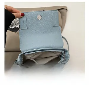 Detailed view of the light blue crossbody bag interior with zip pocket and magnetic flap