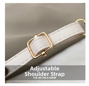 Détail de la bandoulière réglable en cuir blanc avec boucle rectangulaire dorée polie