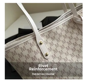 Macro detail of tote bag reinforced gold rivets and monogram pattern on faux leather