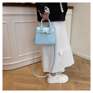 Detail view of the light blue Kelly style bag featuring golden hardware and a twist lock