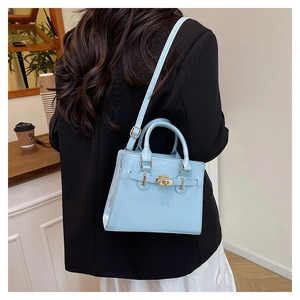 Close-up of light blue structured leather handbag with gold hardware in a cafe setting