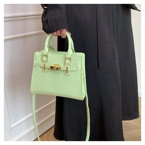 Detail of mint green tote bag with golden lock buckle and adjustable shoulder strap
