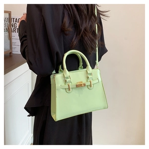 Detail view of mint green PU leather bag with gold twist lock and adjustable strap