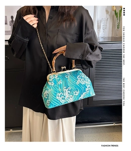 Detail of blue wave pattern handbag with bamboo handle and golden metal clasp