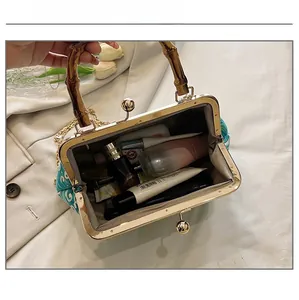 Detail view of retro bamboo handle handbag showing internal capacity for cosmetics