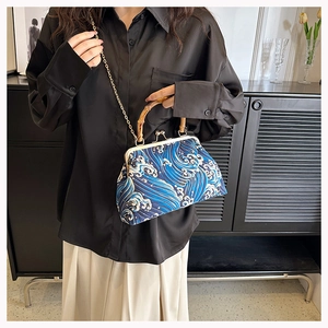 Close-up of retro wave print bag with natural bamboo handle and gold chain strap