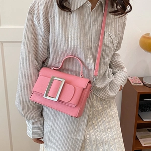 Pink lychee grain leather handbag with large metal buckle and adjustable strap