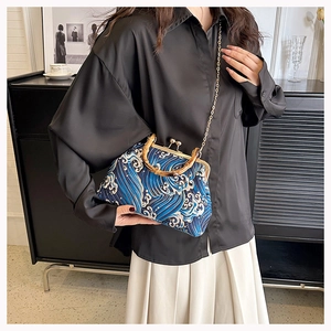 Close-up of retro wave pattern handbag with bamboo handle and gold chain strap