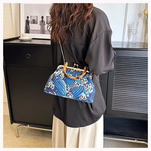 Detail of vintage blue wave pattern bag with bamboo handle and gold chain strap