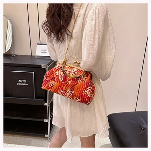 Detail of red wave print kimono bag with bamboo handle and gold chain strap